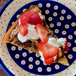 An "Apfel-Eierkuchen" (an apple-egg pancake) dressed up with cream and strawberries